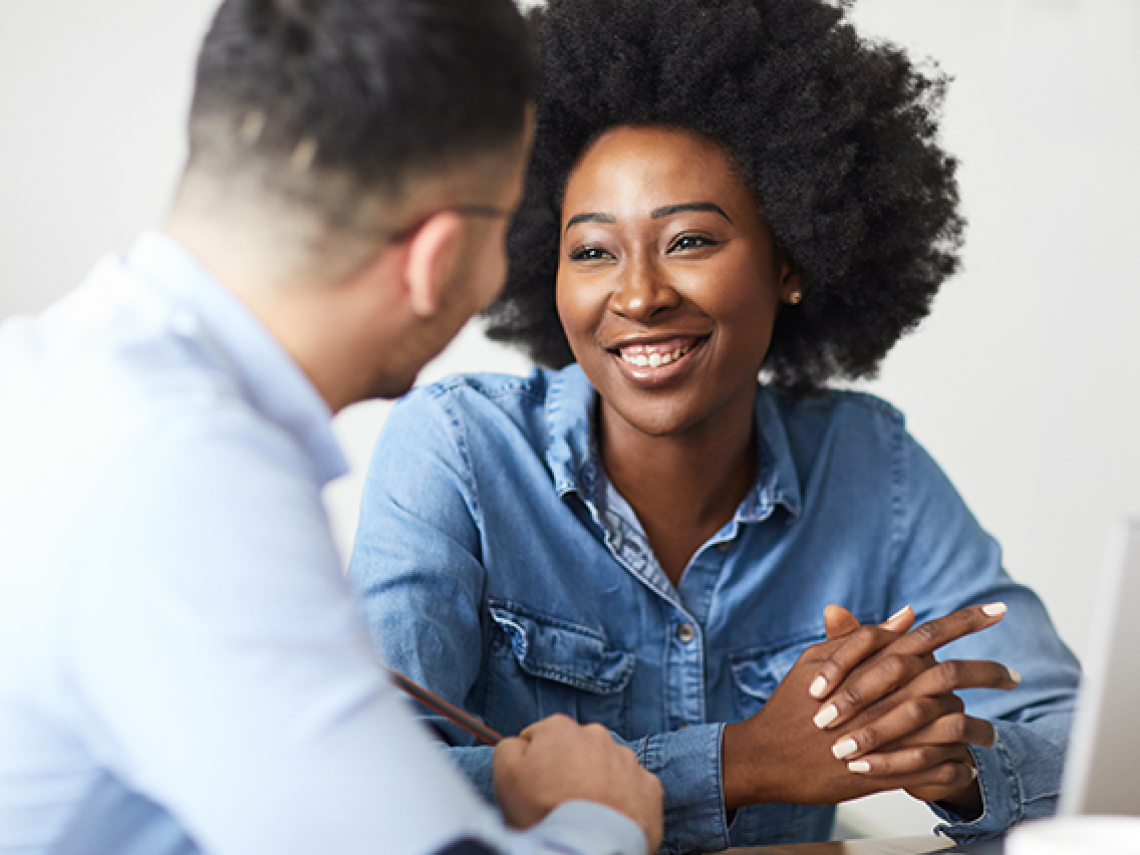 African-American woman smiling talking to a male coworker